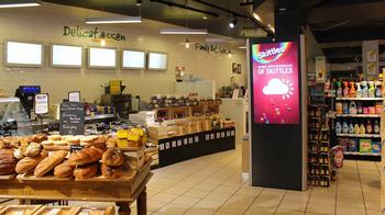 An Adtower display plays an advertiserment for Skittles in an Irish grocery store.