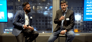 Shows Karim Kanji and Chip Harding sitting side by side on stage at the DPAA Town Hall Event
