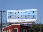 A billboard from Apple's "Shot on iPhone" campaign. It shows a group of people doing a timed shot where they all jumped in the air. It's a good example of how Apple used attractive imagery shot on iPhones to create billboards people notice.