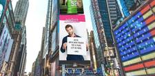 A big, bright Teleflora ad showing one man's confession of love. He is holding a sign that reads "Alicia, we've been friends for 12 years. Let's be more." - James